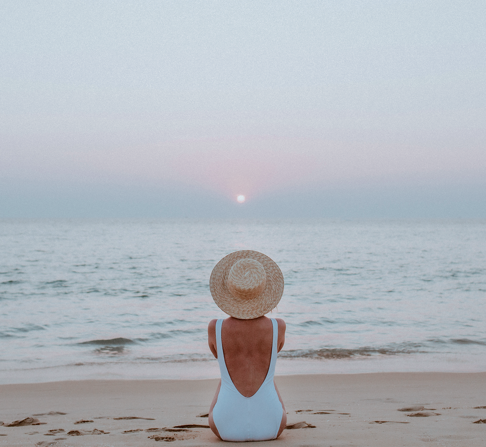 Mujer de espalda contemplando el mar en una playa de Canarias.
